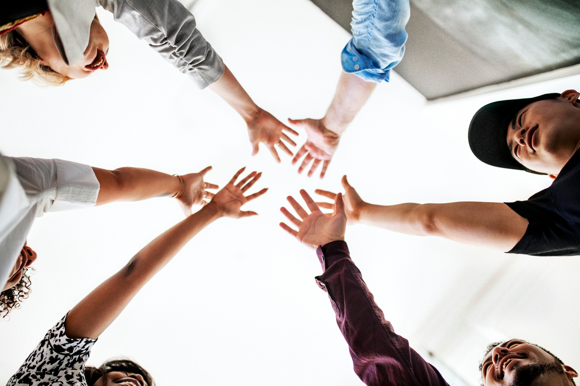 Happy team putting their hands together for success