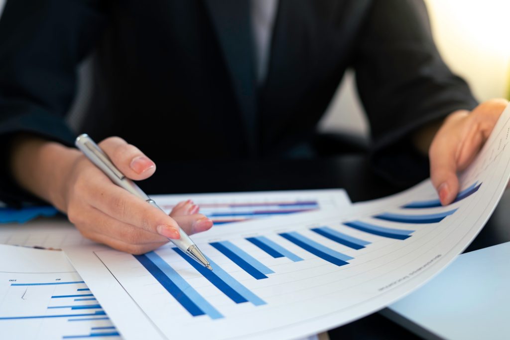 A female finance businesswoman checking the company's financial capital report From graph paper At t